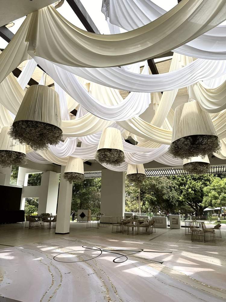 Pantallas con flores colgando en un salón de eventos