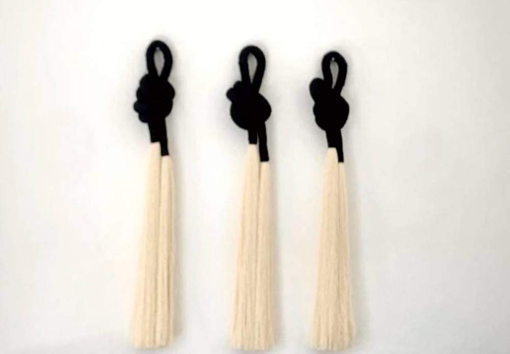 Tres nudos negros con borla de algodón